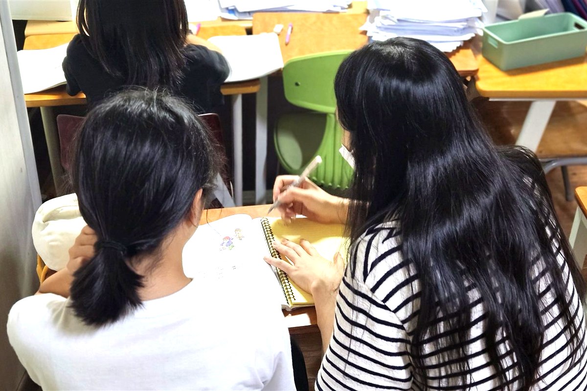로라쌤이 학생 옆에서 영어를 지도하는 모습