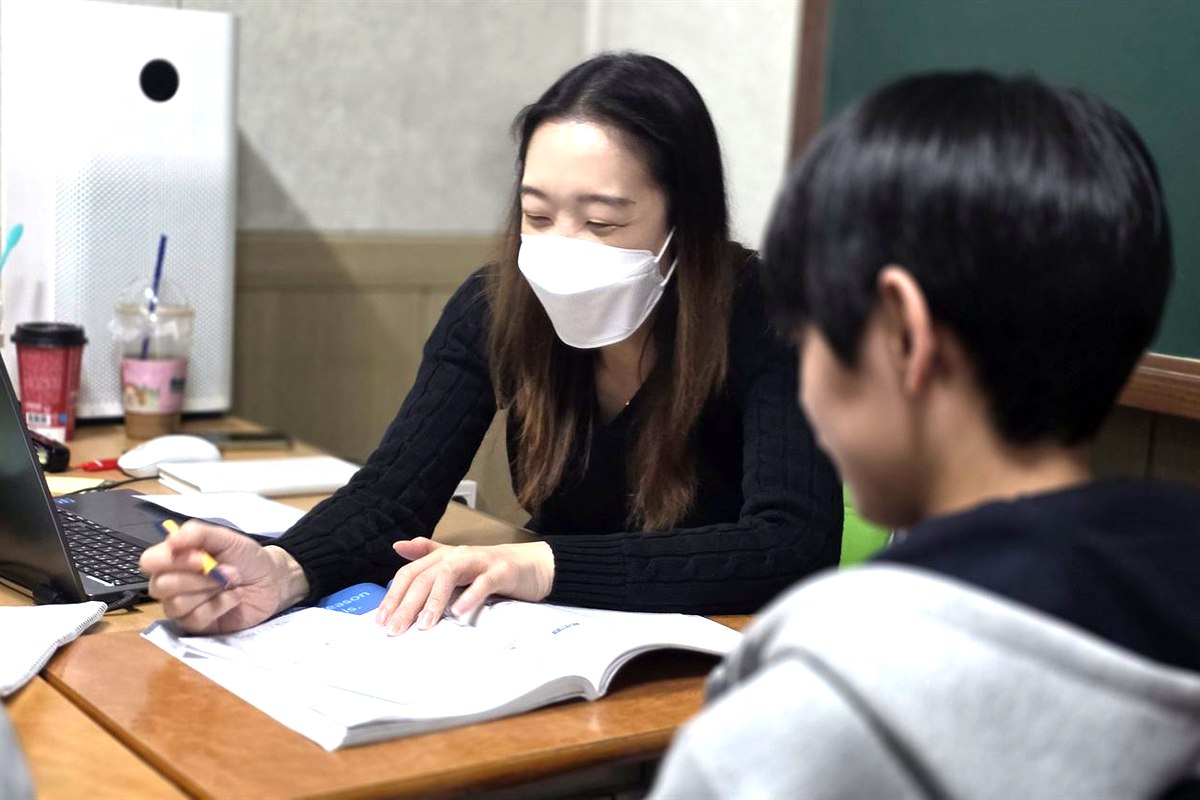 로라쌤이 중등 학생 옆에서 영어를 지도하는 모습